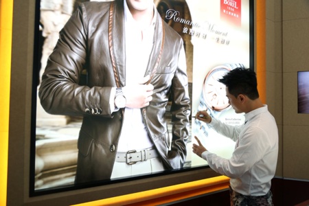 林峯在自己代言品牌的海报上签名留念