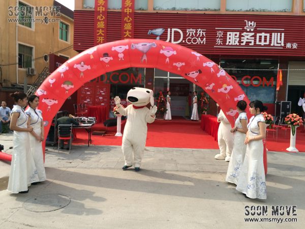 京东狗狗形象的人偶与礼仪人员一起迎宾